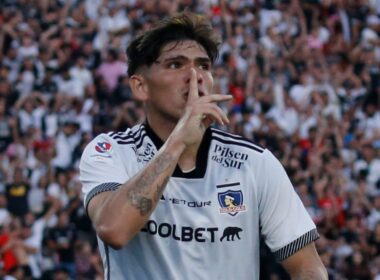 Carlos Palacios celebrando un gol mientras hace silencio con su mano.