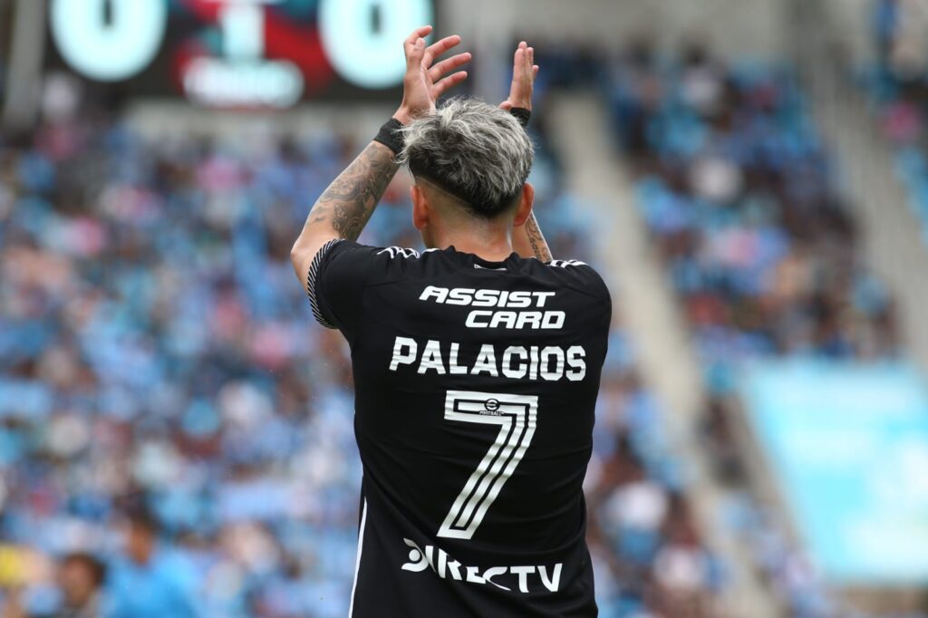 Carlos Palacios de espalda aplaudiendo al público.