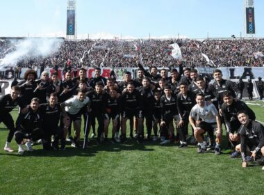 Jugadores de Colo-Colo posando con la hinchada alba de fondo en el sector cordillera.