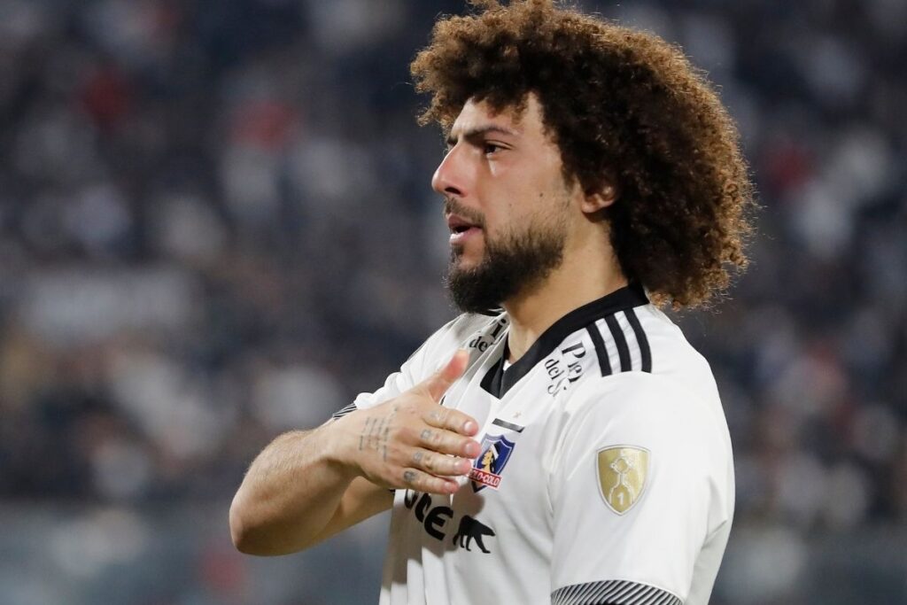 Primer plano a Maximiliano Falcón tocándose el escudo de Colo-Colo.