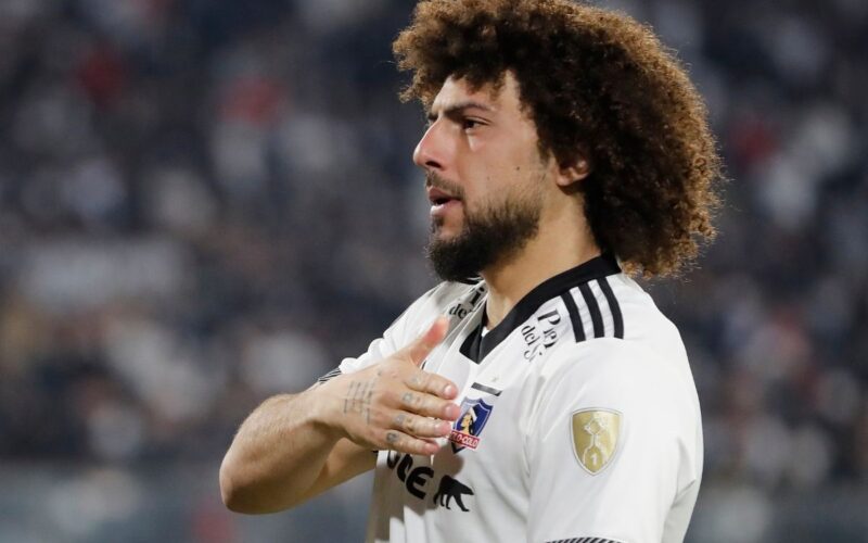 Primer plano a Maximiliano Falcón tocándose el escudo de Colo-Colo.