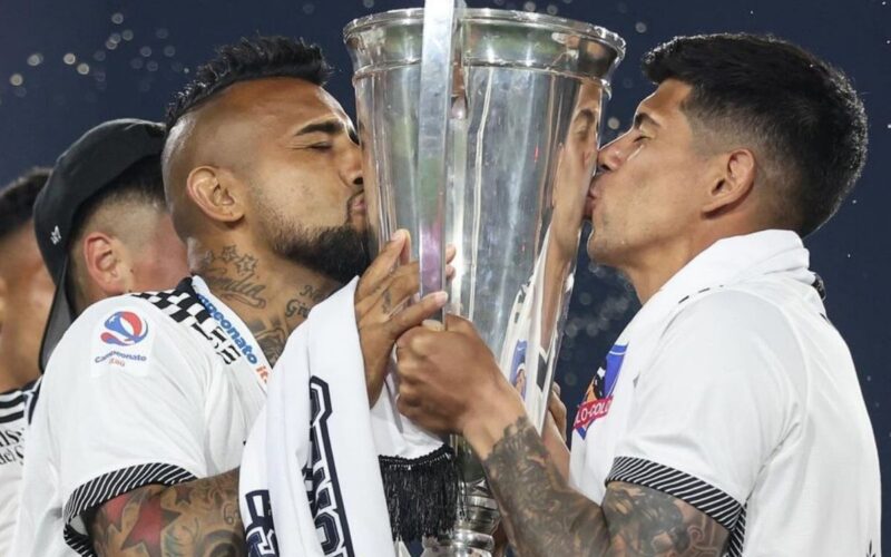 Arturo Vidal y Esteban Pavez besando la copa de Primera División del fútbol chileno.