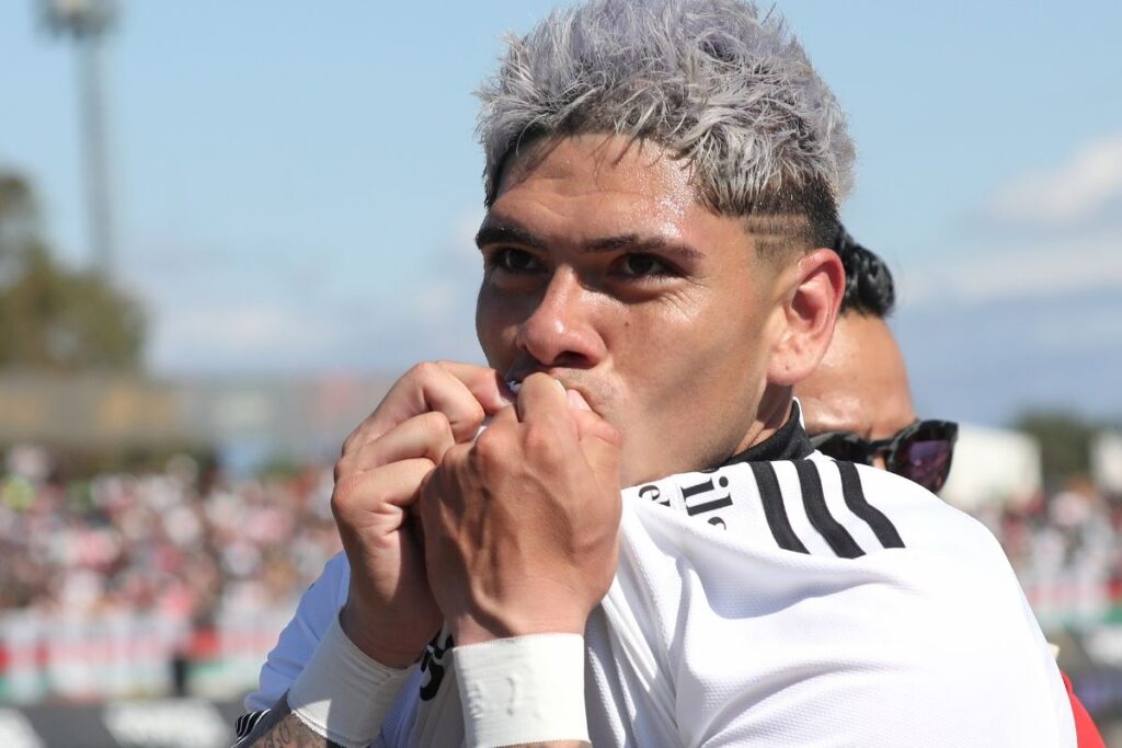 Carlos Palacios celebrando un gol besando el escudo de la camiseta de Colo-Colo.