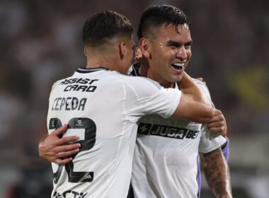 Jugadores de Colo-Colo abrazados celebrando un gol.