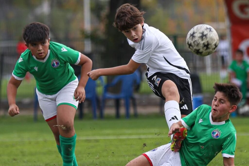 Santiago Neira golpeando el balón durante un partido de Colo-Colo y Audax Italiano por el Torneo de Iniciación.