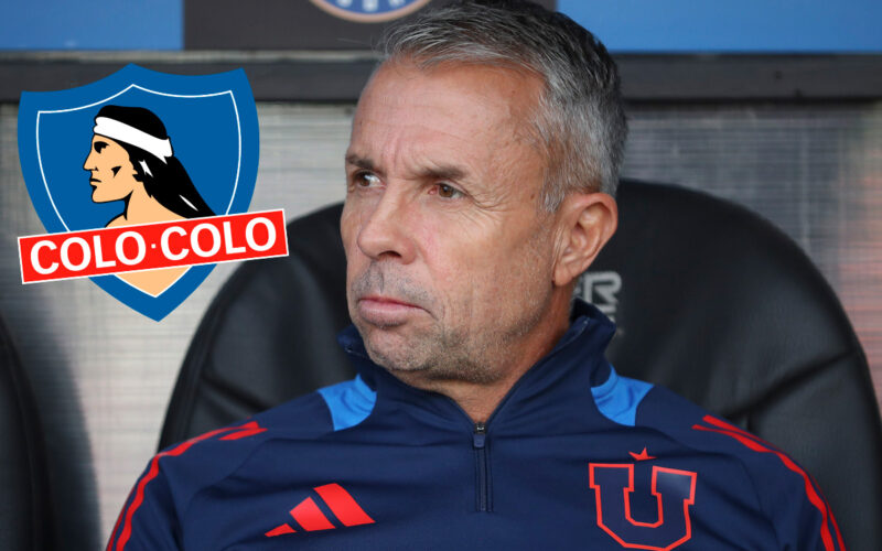 Primer plano de Gustavo Álvarez con indumentaria de Universidad de Chile junto al escudo de Colo-Colo.