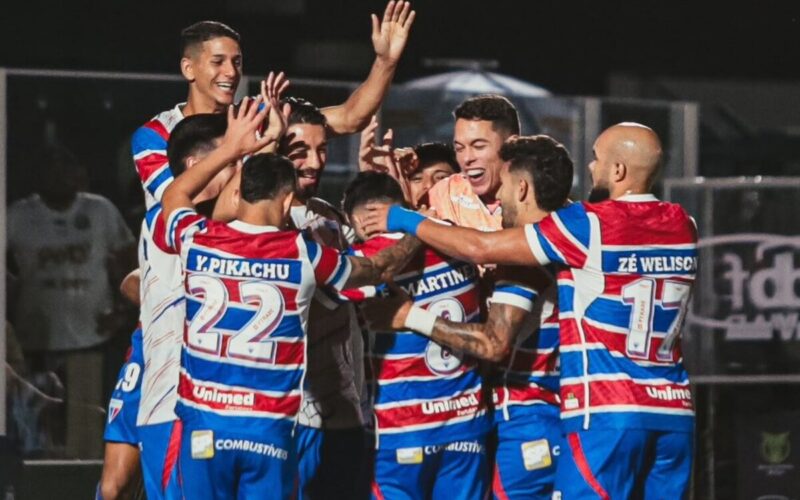Jugadores de Fortaleza abrazados celebrando un gol.