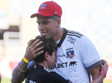 Carlos Palacios con la camiseta de Colo-Colo abrazando a un nuño.