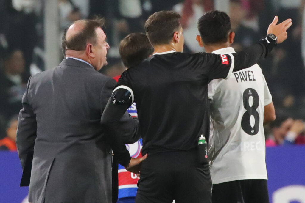 Esteban Pavez junto a un árbitro y representante de la Conmebol.