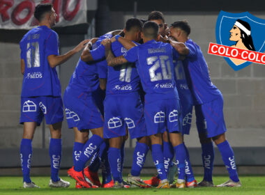 Jugadores de Universidad de Chile abrazados junto al escudo de Colo-Colo.