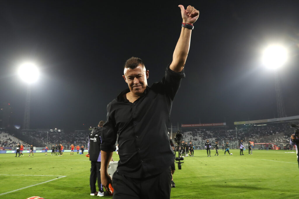 Jorge Almirón con el brazo en alto antes de abandonar la cancha principal del Estadio Monumental.