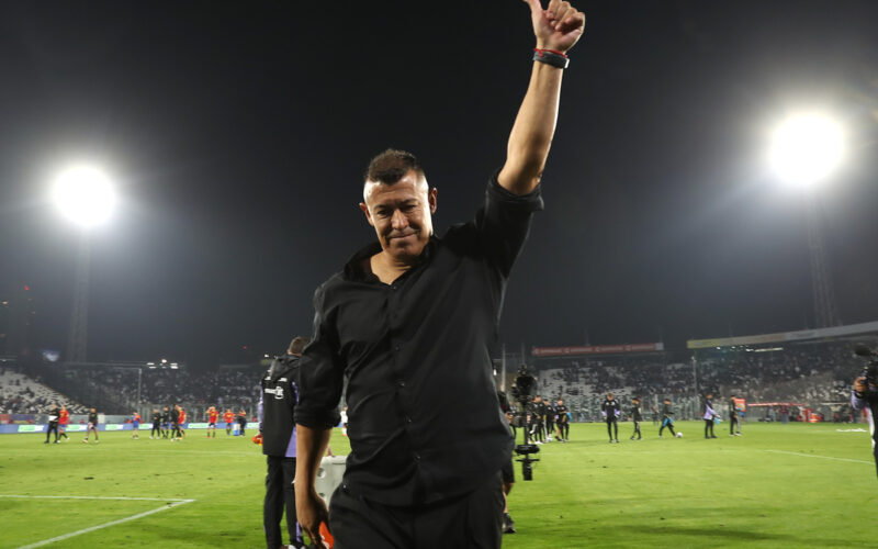Jorge Almirón con el brazo en alto antes de abandonar la cancha principal del Estadio Monumental.