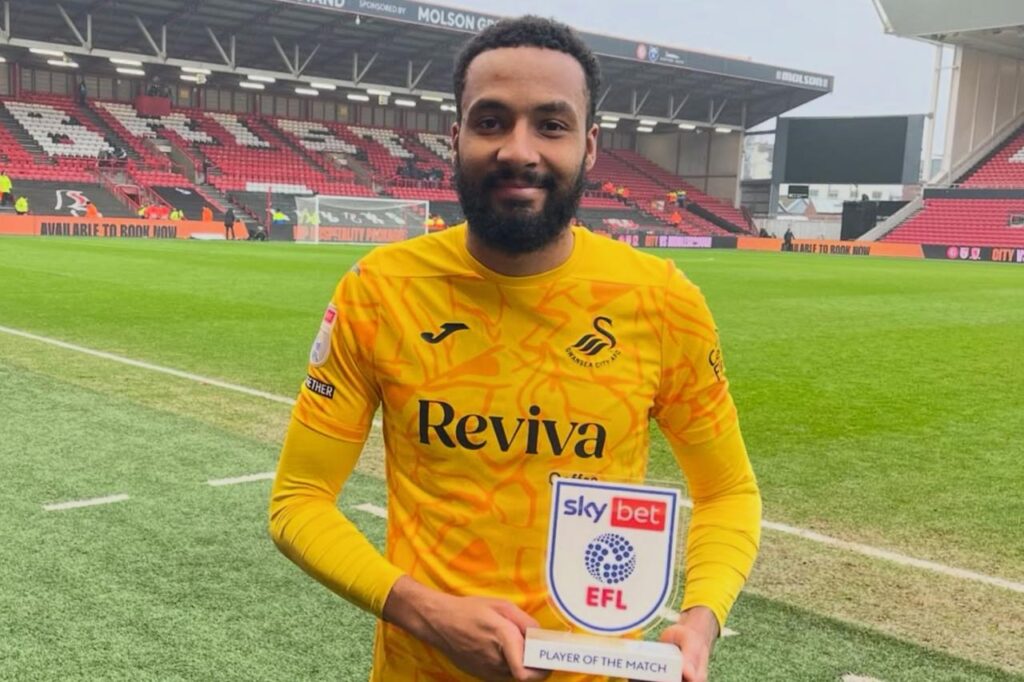 Lawrence Vigouroux con la camiseta del Swansea City con hinchas de fondo.