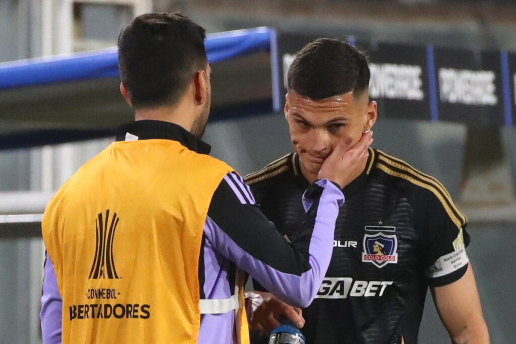 Lucas Cepeda recibiendo el apoyo de un compañero de Colo-Colo.