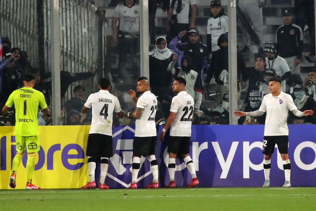 Jugadores de Colo-Colo conteniendo a los hinchas.