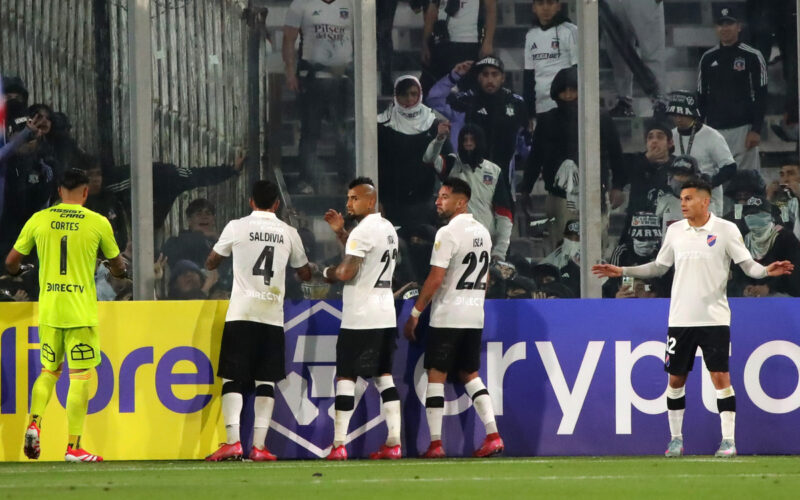 Jugadores de Colo-Colo conteniendo a los hinchas.