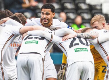Jugadores del Swansea City reunidos con hinchas del club inglés de fondo.