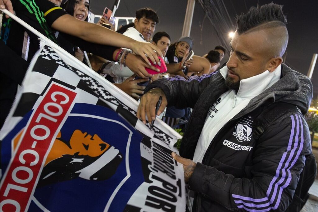 Arturo Vidal firmando una bandera de Colo-Colo.