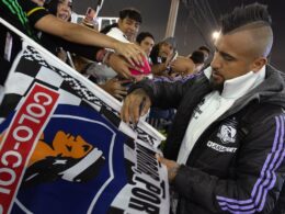 Arturo Vidal firmando una bandera de Colo-Colo.