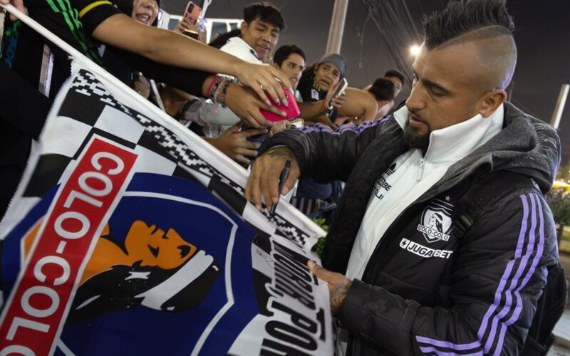 Arturo Vidal firmando una bandera de Colo-Colo.
