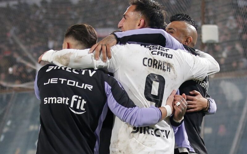 Jugadores de Colo-Colo abrazados celebrando un gol.