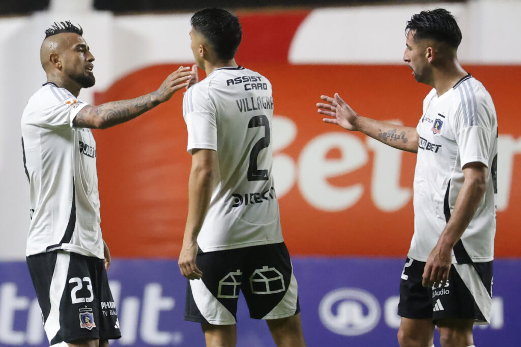 Jugadores de Colo-Colo saludándose durante un partido.
