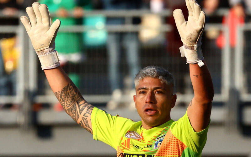 Brayan Cortés con los brazos en alto vistiendo la camiseta de Colo-Colo.