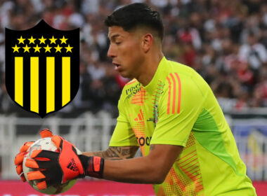 Brayan Cortés atajando un balón durante un partido de Colo-Colo, junto al escudo de Peñarol.