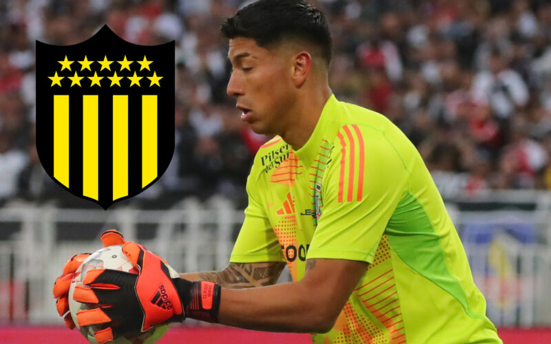 Brayan Cortés atajando un balón durante un partido de Colo-Colo, junto al escudo de Peñarol.