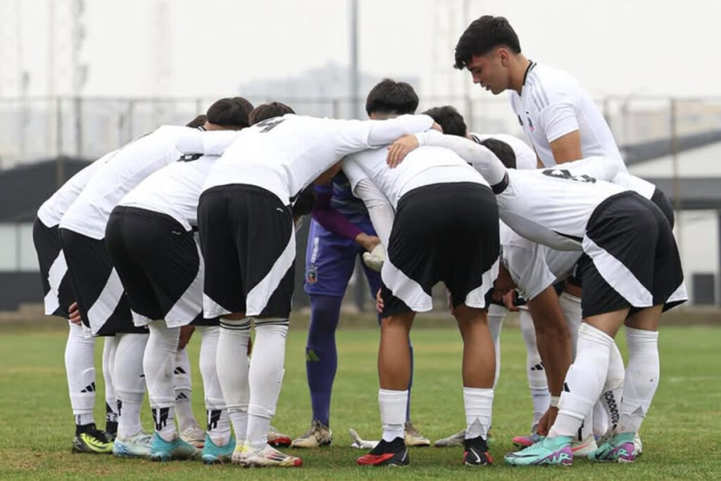 Jugadores de Colo-Colo Sub 18 abrazados en la cancha antes de disputar un partido.