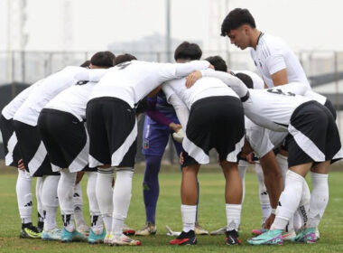 Jugadores de Colo-Colo Sub 18 abrazados en la cancha antes de disputar un partido.