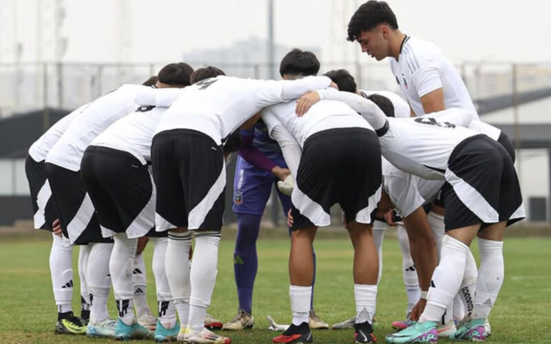 Jugadores de Colo-Colo Sub 18 abrazados en la cancha antes de disputar un partido.