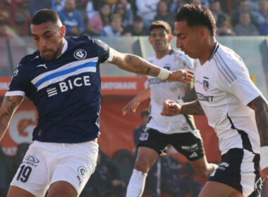 Javier Correa disputando un balón con Branco Ampuero durante un partido entre Colo-Colo y Universidad Católica.