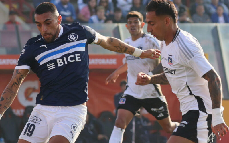 Javier Correa disputando un balón con Branco Ampuero durante un partido entre Colo-Colo y Universidad Católica.