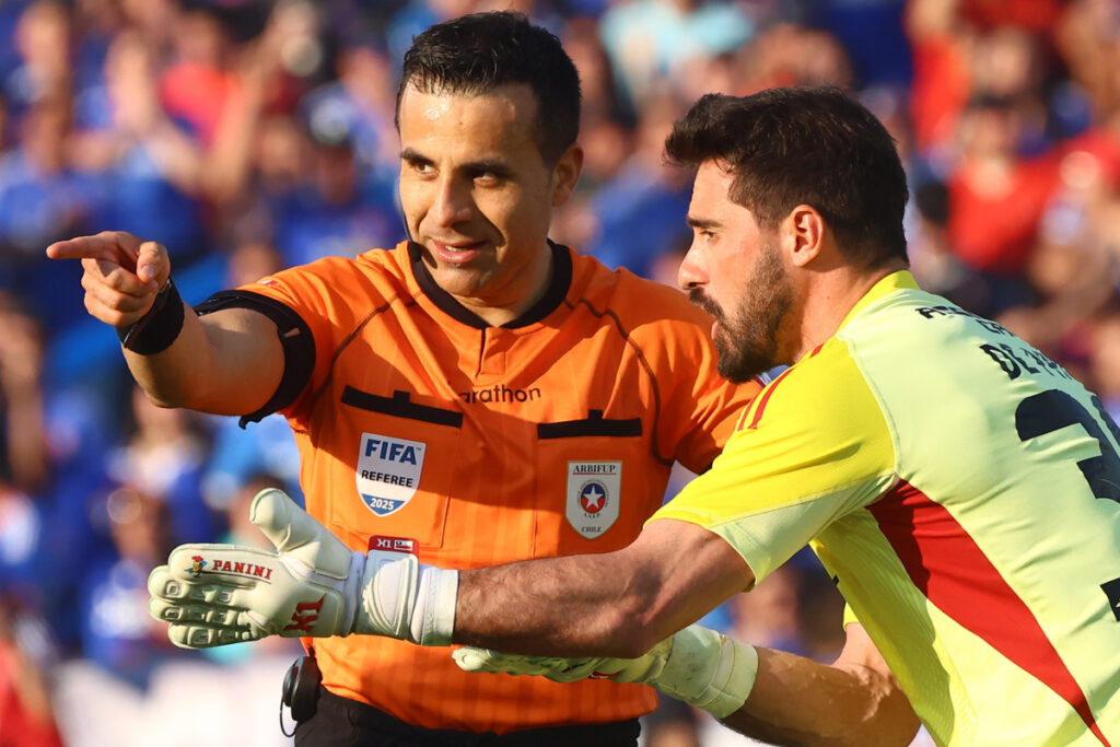 Piero Maza indicando un cobro ante el reclamo de Fernando de Paul durante el Superclásico entre Universidad de Chile y Colo-Colo.