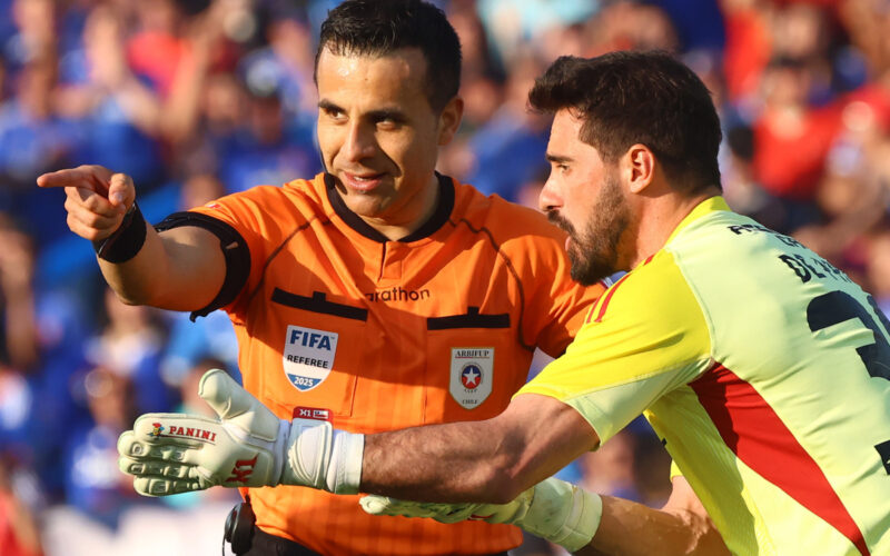 Piero Maza indicando un cobro ante el reclamo de Fernando de Paul durante el Superclásico entre Universidad de Chile y Colo-Colo.