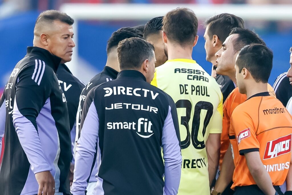 Almirón junto al árbitro Piero Maza.
